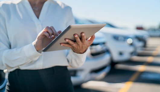 Person using a the product in a tablet in a dealership lot